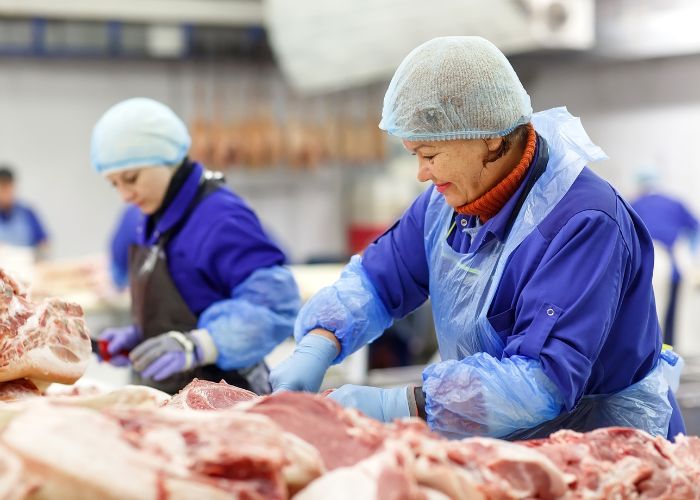 workers in safety gear working with meat