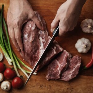 person cutting a meat