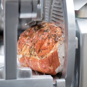 person using gravity meat slicer